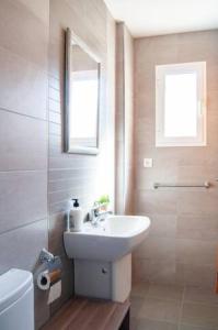 a bathroom with a sink and a toilet and a mirror at Apartamento Cerca del Mar y aeropuerto in Alicante