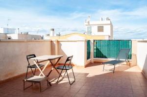 een balkon met een tafel en stoelen op een dak bij Apartamento Cerca del Mar y aeropuerto in Alicante