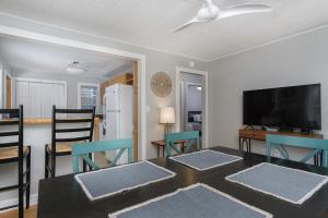 ein Wohnzimmer mit Tisch und Stühlen und einem Fernseher in der Unterkunft Charming Pet-Friendly Cottage Walkable to Town! in Black Mountain