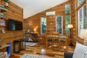 ein Wohnzimmer mit Holzwänden sowie einem Tisch und Stühlen in der Unterkunft Charming Pet-Friendly Cottage Walkable to Town! in Black Mountain