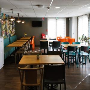 a dining room with wooden tables and chairs at hotelF1 Lyon Bourgoin-Jallieu in LʼIsle-dʼAbeau