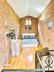 1 dormitorio con cama y pared de ladrillo en sweet home in old tbilisi en Tiflis