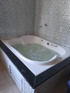 a bath tub filled with green water in a bathroom at Casa de ferias in Barra Velha