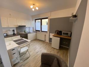 a kitchen with white cabinets and a table and a counter at Ferienwohnung im Lipperland in Bad Salzuflen