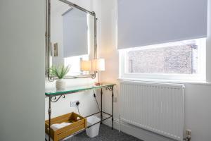 Air Host and Stay - Earp House 3 bedroom, sleeps 7, mins from train في ليفربول: غرفة مع مكتب ومرآة ونافذة