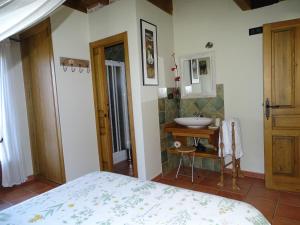 a bathroom with a bed and a sink in a room at Altillo del Aravalle in Umbrías