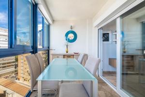 a dining room with a glass table and chairs at Acintur Apartment Levante Beach-Old Town in Benidorm