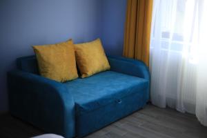 a blue couch with two yellow pillows on it at Sunny Sadgeri in Borjomi