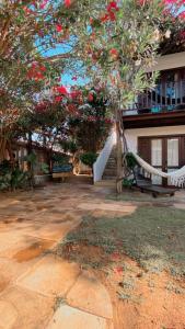 Una casa con un árbol con flores rojas. en Villa Albergaria, en Flecheiras