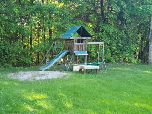 een speeltuin met een glijbaan in het gras bij Countryside Farm Estate - Bnb in Orillia