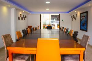 een vergaderzaal met een lange tafel en gele stoelen bij HBS Hotel in Manizales