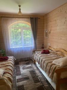 a bedroom with two beds and a window at Готель Ярсон in Yaremche