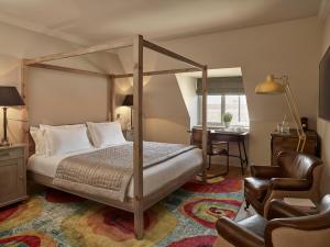 a bedroom with a four poster bed and a chair at The Harper in Langham