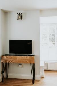 a flat screen tv on a stand in a room at Retreat on the Green in Holt