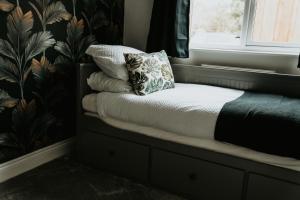 a bed with a pillow sitting on a window sill at Retreat on the Green in Holt