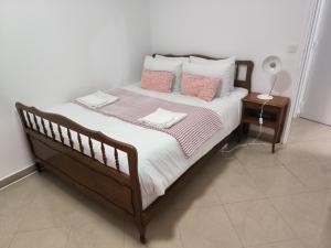 uma cama com lençóis e almofadas cor-de-rosa e brancos em Appartement Cosy em Pavillons-sous-Bois