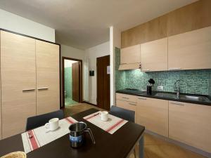 uma cozinha com uma mesa, um lavatório e armários em Residence le Polle em Riolunato