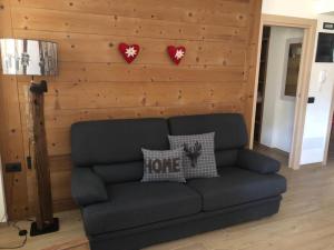 un sofá en una sala de estar con dos corazones en la pared en Baita Filomena, en Livigno
