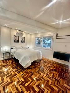 Schlafzimmer mit einem Bett und Holzboden in der Unterkunft Estúdio 196 in Bento Gonçalves