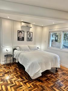 ein Schlafzimmer mit einem großen weißen Bett und einem Fenster in der Unterkunft Estúdio 196 in Bento Gonçalves