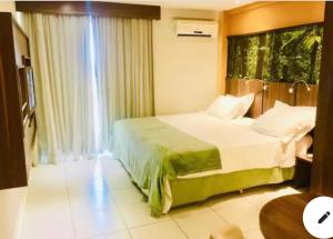 sypialnia z dużym łóżkiem i oknem w obiekcie Flat em hotel Mercure w mieście Nova Iguaçu