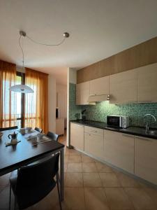 a kitchen with a table and a dining room at Residence le Polle in Riolunato