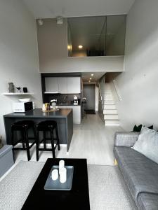 Il comprend un salon et une cuisine avec un canapé et une table. dans l'établissement Penthouse Loft - Near the Airport, à Vantaa