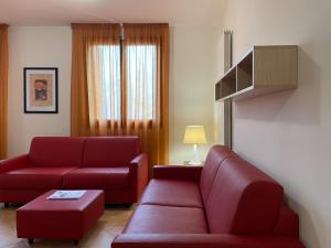 uma sala de estar com mobiliário vermelho e um sofá vermelho em Residence le Polle em Riolunato