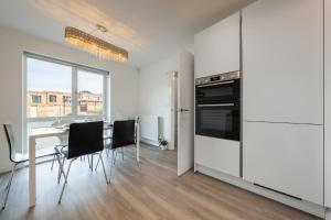 een keuken en eetkamer met een tafel en stoelen bij 3 bedroom house in Bricketwood St Albans in Garston