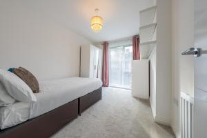 um quarto com uma cama e uma grande janela em 3 bedroom house in Bricketwood St Albans em Garston