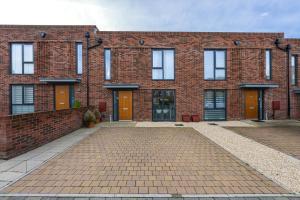 un edificio de ladrillo con puertas naranjas y entrada de ladrillo en 3 bedroom house in Bricketwood St Albans en Garston