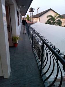 a man walking down a balcony with a fence at 3TS LUXURY APARTMENTS in Sangotedo