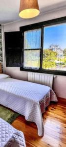 a bedroom with two beds and a large window at El Acebu in Colombres