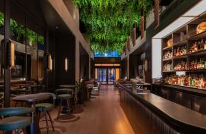 a bar at a restaurant with bar stools at Thompson Central Park New York, by Hyatt in New York