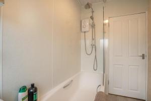 a bathroom with a shower and a white tub at 2 Bed Bungalow - Free Parking 