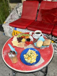 uma mesa vermelha com pratos de comida e uma chávena de café em Homeplanet Hostel em Leipzig