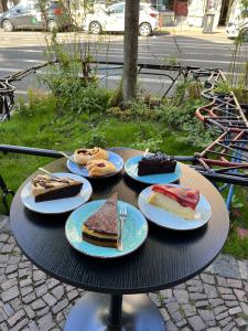 una mesa con cuatro platos de comida. en Homeplanet Hostel en Leipzig