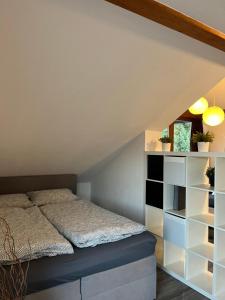 ein Schlafzimmer mit einem Bett im Dachgeschoss in der Unterkunft Appartement mit Blick ins Grüne in Viereth-Trunstadt