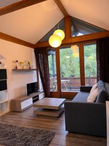ein Wohnzimmer mit einem Sofa und einem großen Fenster in der Unterkunft Appartement mit Blick ins Grüne in Viereth-Trunstadt