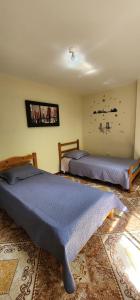 two beds sitting in a room with at apartamento para turistas Solangel in San Gil