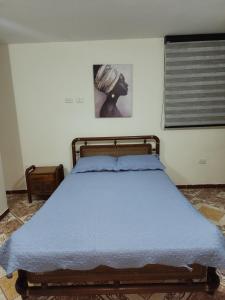 a bedroom with a bed with a blue blanket at apartamento para turistas Solangel in San Gil
