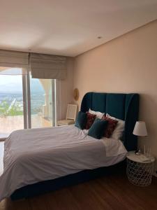 a bedroom with a large bed with a large window at Luxueux VILLA avec jardin et vue panoramique in Tetouan