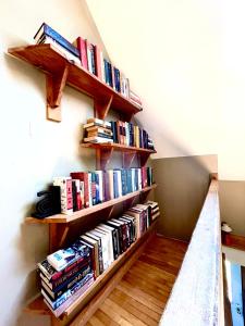 a book shelf filled with books on a wall at M.Ruth Retreats in the Orchard 