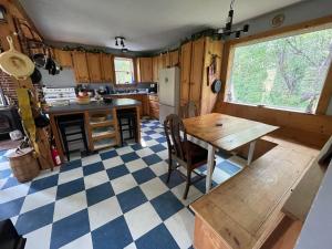 een keuken met een houten tafel en een geruite vloer bij M.Ruth Retreats in the Orchard 
