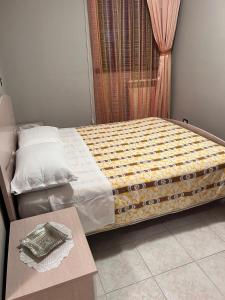 Una cama en una habitación con una mesa delante en Residence San Martino Appartamento mini en Busso