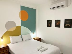 a bedroom with a white bed and a colorful wall at Villaok in Kuta