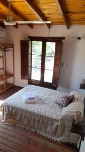 um quarto com uma cama grande e um tecto em madeira em POSADA LAS MARGARITAS em Santa Rosa de Calamuchita
