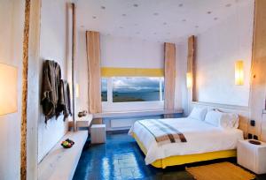 a bedroom with a bed and a large window at Remota in Puerto Natales