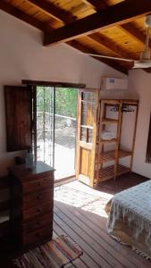 um quarto com uma cama e uma porta de vidro deslizante em POSADA LAS MARGARITAS em Santa Rosa de Calamuchita