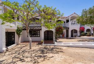 ein weißes Haus mit einem Baum davor in der Unterkunft La Hacienda San Felipe Condo 18 in San Felipe